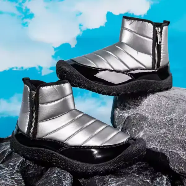 A pair of New Down Fabric Waterproof Snow Boots for men with double zippers, black soles, and warm thickened lining are shown on dark rocks against a bright blue sky with clouds.