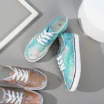 Two pairs of Wholesale China Factory Round Toe Unisex Tie Dye Canvas Shoes for women—one blue/green, the other brown/green—are displayed on a gray and white background.