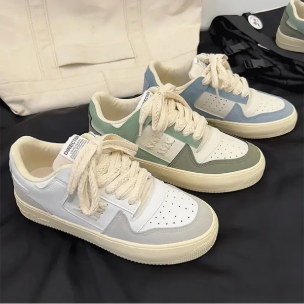 Three pairs of Factory Wholesale Retro Breathable Men Sneakers in white with pastel blue, green, and gray accents are displayed on a surface with a cream-colored bag in the background.