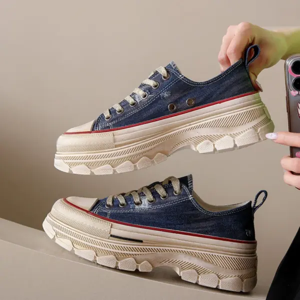 A person holds a pair of Women’s Casual Walking Style Canvas Chunky Shoes featuring blue denim uppers, cream-colored soles, and red accents against a neutral background.
