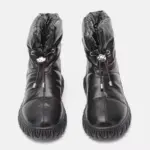 A pair of black genuine leather waterproof snow boots with plush thick fur, quilted uppers, drawstring closures, and textured rubber soles—ideal for OEM/ODM customization.