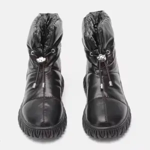 A pair of black genuine leather waterproof snow boots with plush thick fur, quilted uppers, drawstring closures, and textured rubber soles—ideal for OEM/ODM customization.