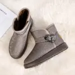 A pair of gray wholesale customized OEM ODM plush thick waterproof faux fur winter ankle boots for women, ideal for snow, displayed on a white fuzzy surface.