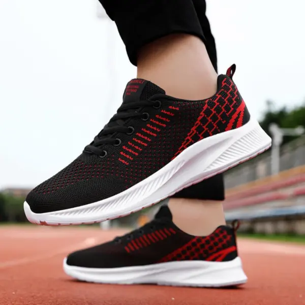 A person wearing Men’s Casual Sneakers—black mesh, lightweight, flying weaving lace-up with white EVA soles—stands on a running track, ideal for OEM/ODM sportswear brands prioritizing quality and style.