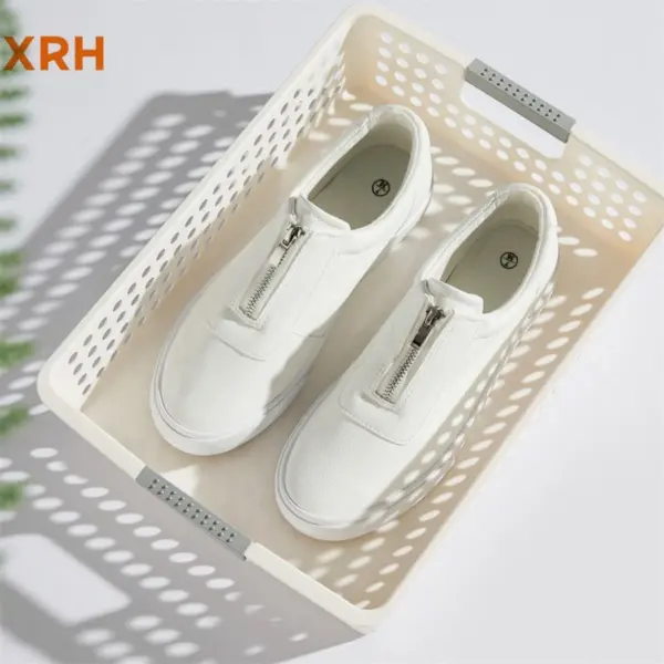 Low Freight White Tennis Canvas Sneakers, perfect for OEM ODM orders, are placed in a beige plastic basket with perforated sides and gray handles. These ladies' black walking shoes loafers offer new styles for women.