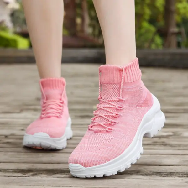 A person wearing XRH Wenzhou Factory Thick Bottom Increase Sneaker High Top Chunky Shoes for women with white thick soles stands outdoors on wood, greenery in the background.