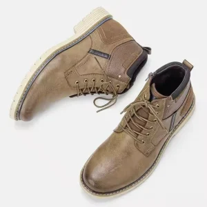 A pair of Handmade Fashionable Winter Warm Ankle Boots for men in brown with light-colored soles, vintage Roman style, viewed from above on a white background.