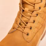 Close-up of the 2025 Winter Snow Ankle Boots—tan lace-up boots with metal eyelets, visible stitching, and textured leather—ideal for OEM/ODM customization. Suitable for men, women, and ladies seeking high heel platform styles.