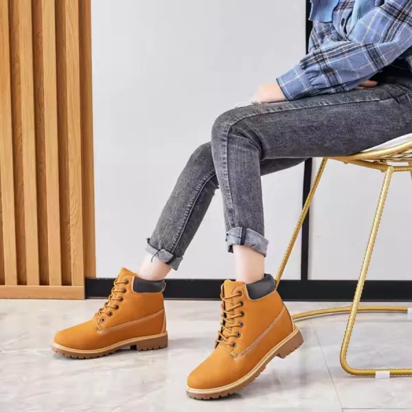 A person sits on a chair wearing rolled-up jeans, a blue plaid shirt, and Women Snow High Top Mountain Climbing Ankle Boots Anti-slip Outdoor Leather Boots for Women.