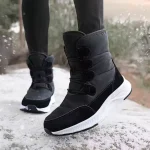 A person wearing Wholesale Wear Resistant Outdoor Cotton Snow Boots PU High Top Round Toe Rubber Women's Shoes with white soles stands on a snowy surface, trees visible in the background.