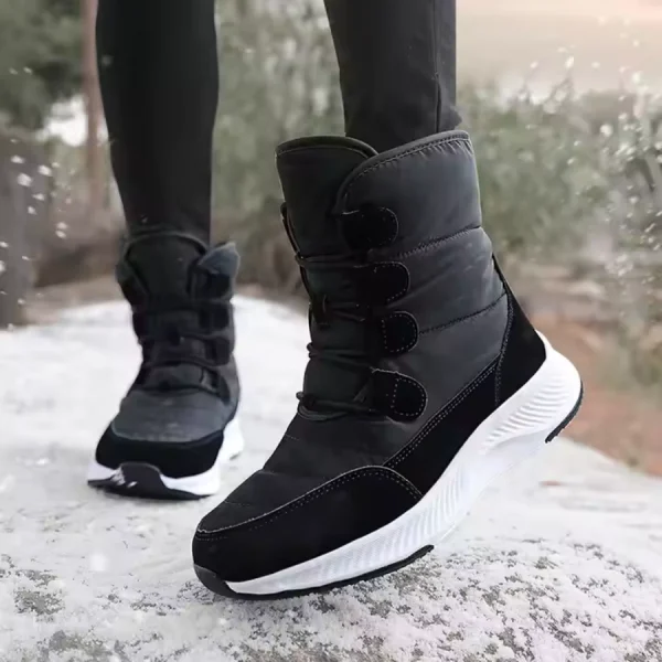A person wearing Wholesale Wear Resistant Outdoor Cotton Snow Boots PU High Top Round Toe Rubber Women's Shoes with white soles stands on a snowy surface, trees visible in the background.