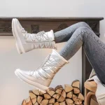 A person wearing Wholesale Fashion Fur Collar Winter Chestnut Snow Boots Women Thick Non Slip Warm Lace up Snow Boots and gray jeans sits with legs raised before a fireplace mantel and stacked firewood.