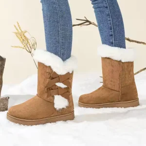 A person wearing Fashion Walking Style Boots for Women—Low Price Heel Snow Outdoor Warm Boots Ladies Winter Boots—stands on snow with bare branches, making them ideal for OEM and ODM winter footwear collections.